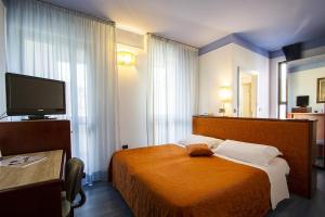 a hotel room with a bed and a flat screen tv at Hotel sirena in Cesenatico