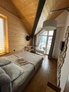 a bedroom with a large bed and a large window at Girske Povitria 2 in Yaremche