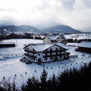 un gran edificio con nieve en un campo en Complex Panicel, en Râșnov