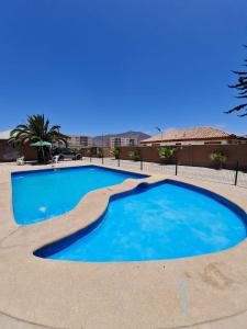 una gran piscina azul en un patio en Cabañas con piscina donde Thomas, en La Serena
