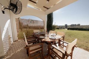 a wooden table and chairs on a patio at Calas Sani Villas in Filakaí Kassándras