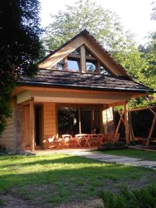 a house with a porch with tables and chairs at UROCZY DOMEK in Brenna