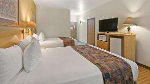 Best Western Gold Canyon Inn & Suites في Gold Canyon: غرفة فندقية بسريرين وتلفزيون بشاشة مسطحة