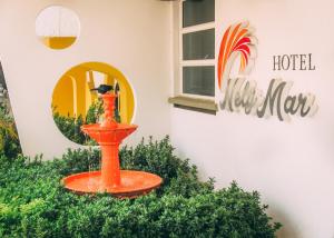 an orange bird bath in front of a hotel sign at Hotel NelyMar in Santa Marta