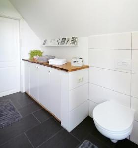 een witte badkamer met een toilet en een wastafel bij Ferienhaus BB2 in Bad Brambach