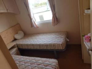 um pequeno quarto com 2 camas e uma janela em C8 em Aberystwyth