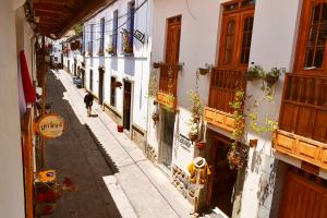 een steeg met een persoon die door een straat loopt bij Native Soul Guesthouse in Cuzco