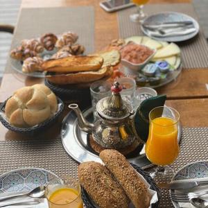 een tafel met een ontbijt van brood en jus d'orange bij Teuta Palace Dom Faletići in Sarajevo