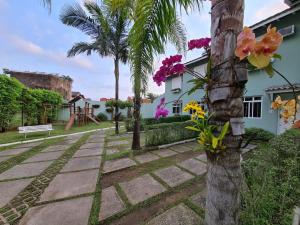 a garden with a palm tree and a playground at Casinha de Boneca em Juquey in Juquei