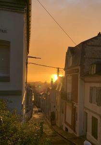 een uitzicht op de zonsondergang vanuit een straat met gebouwen bij Cristal House in Trouville-sur-Mer