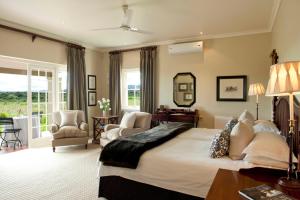 a bedroom with a large bed and a table and chairs at RiverBend Lodge in Addo +90 photos