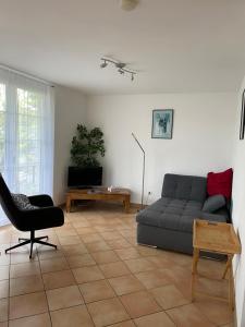 a living room with a couch and a chair at Ferienwohnung Am Gießbach 15 in Bodman-Ludwigshafen