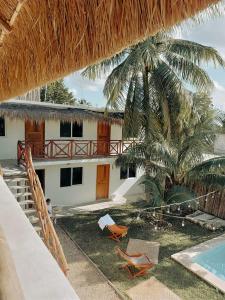 een huis met een palmboom en een zwembad bij Hotel Xa´an Bacalar in Bacalar
