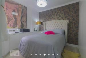 a bedroom with a white bed with a pink pillow at IBC/Autodromo/Aeroporto/Expo SP/PQ da Monica/Transamerica in Sao Paulo