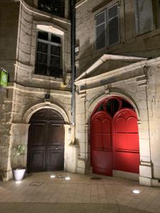 dos puertas rojas en el lateral de un edificio en Les Tiercelines en Dole