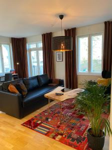 a living room with a black couch and a table at Stava Mosters in Mariehamn