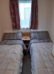 two beds in a small room with a window at 58 Newquay View, Newquay Bay Resort in Porth +15 photos
