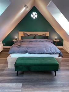 a bedroom with a large bed with a green wall at Pauernhof Ferienwohnungen in Bad Nenndorf