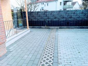 a brick courtyard with a fence and a brick wall at FMI44Apartment in Rüsselsheim