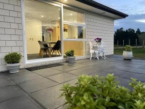 a screened in porch with a table and chairs at Veld View Bed and Breakfast in Tuakau