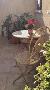 una mesa con 2 sillas y una mesa con flores en B resort דירת נופש בדרום רמת הגולן, en Giv'at Yo'av