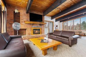 a living room with leather furniture and a fireplace at 12 Beds Sleep 16 Chalet with HotTub, 2min to Blue in Blue Mountains