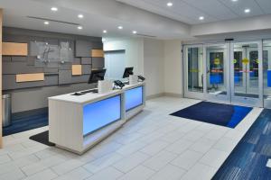 an office lobby with a reception desk and windows at Holiday Inn Express Orlando - South Park by IHG in Orlando +127 photos