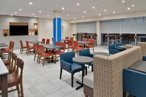 a dining room with tables and chairs and tablesktop at Holiday Inn Express Orlando - South Park, an IHG Hotel in Orlando