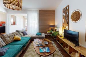 a living room with a green couch and a television at ilococo in Sainte-Anne