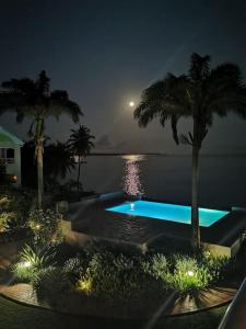 a swimming pool in the middle of the water at night at ilococo in Sainte-Anne