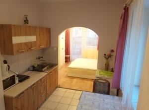 eine Küche mit einem Waschbecken und ein Zimmer mit einem Bett in der Unterkunft Bötös Villa Haus in Hévíz