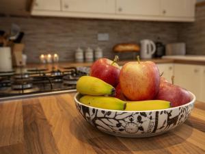 a bowl of apples and bananas on a counter in a kitchen at The Yorkshire Hosts - Fall in Green Cottage in Haworth