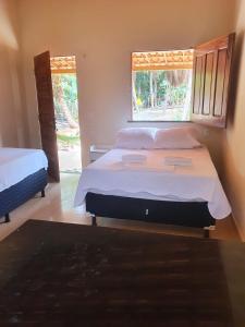um quarto com uma cama grande e uma janela em Chalés Caiçara Praia de Ponta Grossa em Icapuí
