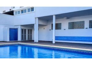 une piscine en face d'un bâtiment dans l'établissement Ático Baladrar Gran Terraza-Disponible 22Jul a 1Agost y 17Agosto hacia delante-APTO A 8Km Playa Dénia-Oliva Nova Golf -IDEAL Familias y Grupos, à Pego
