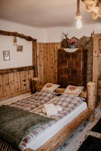 two beds in a room with wooden walls at Chatka Zapiecek in Krościenko