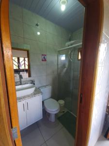 y baño con aseo, lavabo y ducha. en Chalés Rota das Cachoeiras en Urupema