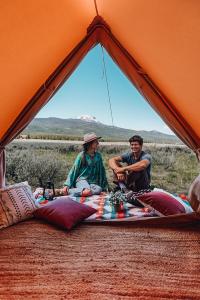 a group of three men sitting in a tent at Wander Camp Yellowstone in Island Park +14 photos