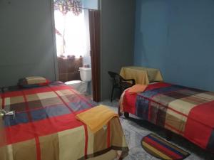 1 dormitorio con 2 camas y ventana en Hospedaje Arvakeni en San Cristóbal