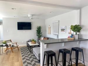 a kitchen and living room with a counter and stools at Steps To The Beach, Pacific City and Main Street - #5 in Huntington Beach