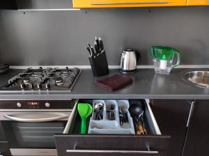 a kitchen counter with a stove and a drawer with utensils at Designer apartment in THE CENTER in Pyatigorsk
