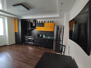 a kitchen with black and yellow cabinets and a table at Designer apartment in THE CENTER in Pyatigorsk