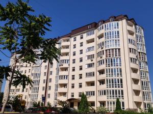 a tall white building with trees in front of it at Designer apartment in THE CENTER in Pyatigorsk