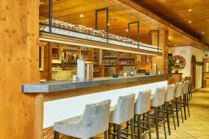 un bar avec une rangée de chaises dans un restaurant dans l'établissement Ruperti - Gästehaus, à Ainring