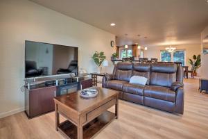 a living room with a leather couch and a tv at Spacious Bandon Getaway - 2 Blocks to Ocean! in Bandon