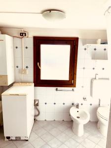 a bathroom with a toilet and a window at Alloggio in vetta alla montagna in Montese