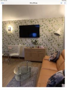 a living room with a couch and a tv on a wall at The Annex Apartment is on Cheddar Bridge Apartments in Cheddar