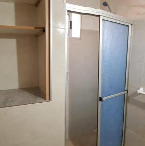 a shower with a blue door in a bathroom at La Quimera del Águila in Atlántida