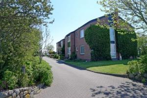 a brick house with a driveway in front of it at Hus an de Marsch in Midlum