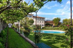 a garden with a swimming pool and a building at Villa La Preziosa in Lucca