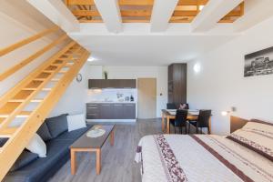 a bedroom with a bed and a couch and a kitchen at Apartmány Sophia 7 in Velké Losiny